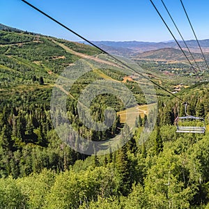 Square frame Chairlifts and aerial view of mountain hiking trails and buildings in summer