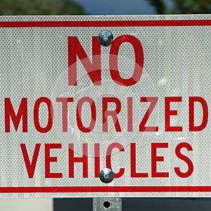 Square frame Close up view of a white and red sign that reads No Motorized Vehicles