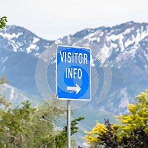 Square frame Close up of a Visitor Info sign with trees snowy mountain and sky background