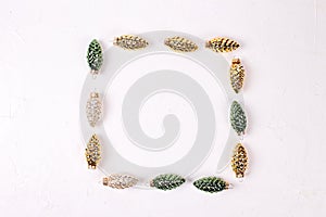 Square frame from decorative golden, green and silver pine cone