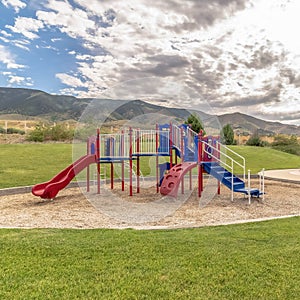 Square frame Fun childrens playground with amazing view of cloudy blue sky and mountain