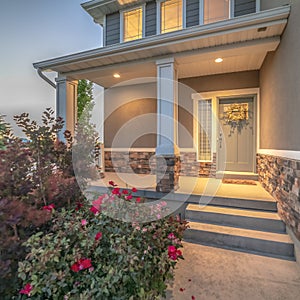 Square frame Home entrance with pathway and stairs leading to porch and door with wreath