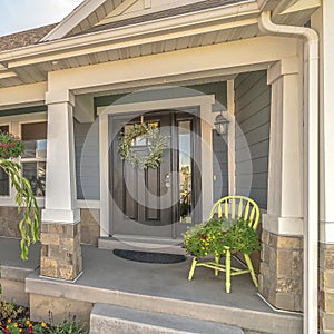 Square frame Home with landscaped yard stairs porch and front door with sidelight and wreath