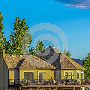 Square frame Home trees and mountain on a scenic landscape under blue sky and puffy clouds