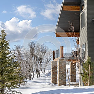 Square frame Home with wood and stone wall and balcony with Wasatch Mountain terrain view