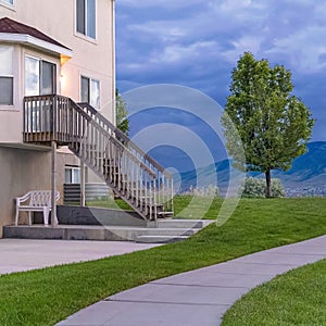 Square frame Pathway in front of a home with stairs leading to the second floor entrance