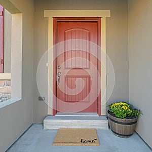 Square frame The red front door of a house with concrete exterior wall and shutters on window