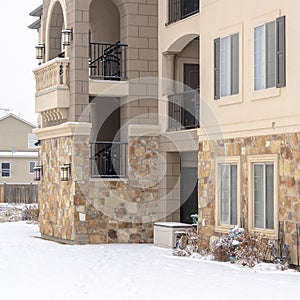 Square frame Residential apartment building facade with snow covered yard in winter