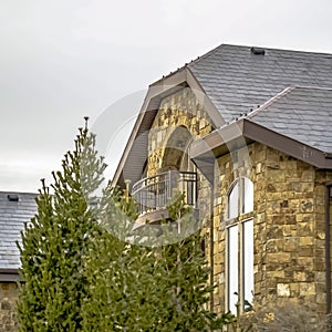 Square frame Stone home with half circle balcony and quarter round with extended leg window