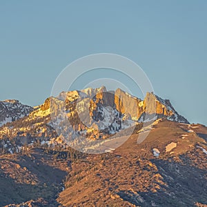 Square frame Striking mountain peak with rugged slopes against blue sky on a sunny day