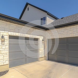 Square frame Three car garage and driveway of suburban home