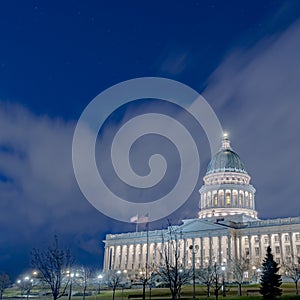 Square frame Utah State Capital Building glowing against sky and clouds in Salt Lake City