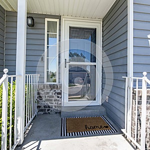 Square Front porch of a house with glass storm door with sidelight