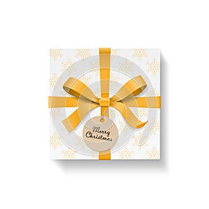 Square gift box, gold color bow knot and ribbon with circle kraft hang tag. Snowflake pattern paper.