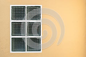 Square glass block windows on orange cement wall texture background