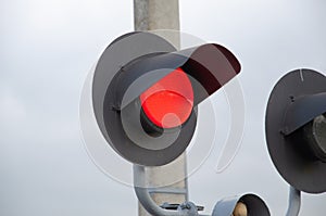 Square Grade crossing signal with red light gate and crossbuck at railroad crossing.