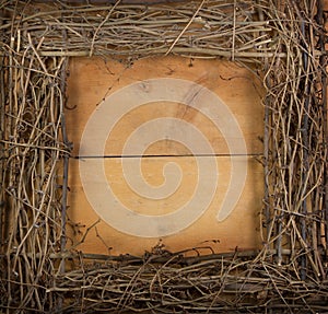 A square grapevine wreath on a wooden background