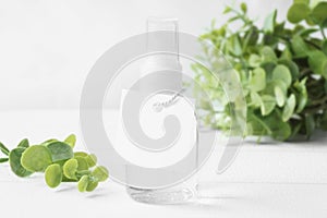 Square hang tag mockup on hand sanitiser bottle  with greeneries.