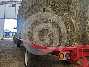Square hay bales stacked on a tractor and trailer