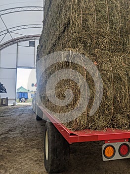 Square hay bales stacked on a tractor and trailer