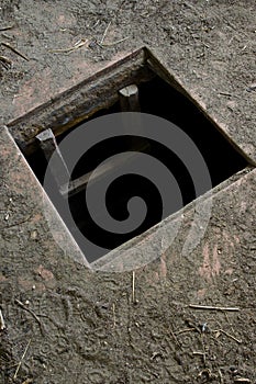 Hole in floor of old house leading to cellar