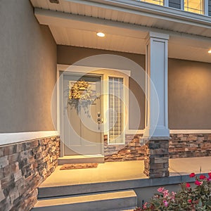 Square Home entrance with pathway and stairs leading to porch and door with wreath