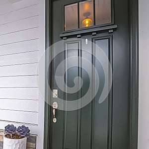 Square Home facade with glass paned front door and furniture on the concrete porch