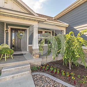 Square Home with landscaped yard stairs porch and front door with sidelight and wreath