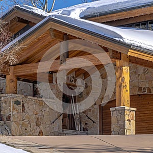 Square Home in Park City Utah with snowy gable roofs stone wall and outdoor stairs