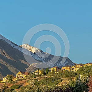 Square Houses on a hill with view of snowy mountain and cloudless blue sky