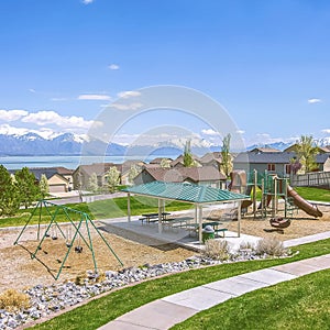 Square Houses and park with playground and picnic area on a neighborhood near a lake