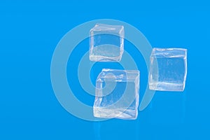 Square ice cubes on blue background. Cold beverages. Refreshing drinks ingredients. Copy space