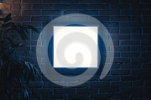 Square Illuminated Frame Mounted on Dark Brick Wall