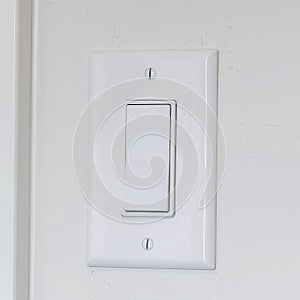 Square Indoor electrical light switch of home mounted on white wall background