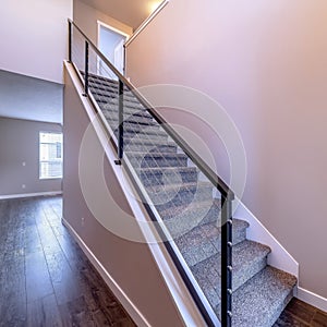 Square Indoor staircase against brown wooden floor and plain white wall of home