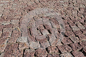 Square lined with cobblestone or stone pavement, walkway or road.