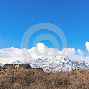 Square Magnificent mountain coated with snow against a vivid sky with puffy clouds