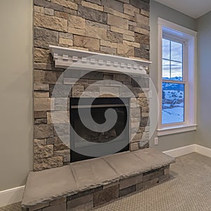 Square Modern fireplace and decorative shelf against stone brick accent wall of home