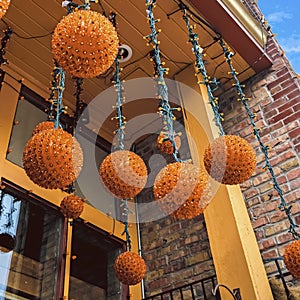 Square Orange light balls hanging at the entrance of a building with red brick wall