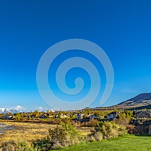 Square Panoramic view of a lake and snow covered mountain under deep blue sky