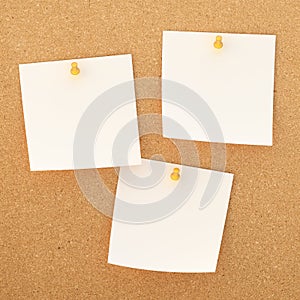 Square paper notes over cork board