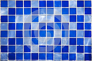 Square pattern of blue and light blue tiles for bath walls and floor design or swimming pool design. Water blinks on tiled walls i photo