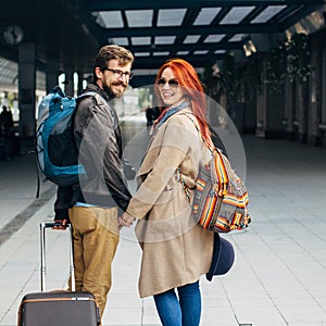 Square photo. Real view of amorous hipster couple walking down station and chatting outdoors. Holyday concept