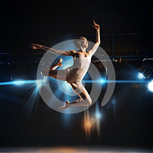 Square photo of young blonde ballet dancer in jump on stage