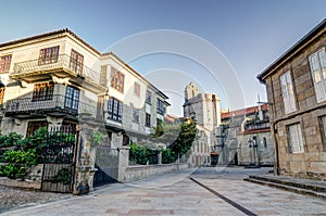 A square in Pontevedra Spain with a church as background and some buildings with plants and a spanish flag