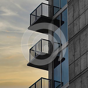 Square Puffy clouds at sunset Side of a tall building with railings on the balconies at Salt L