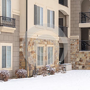 Square Residential apartment building facade with snow covered yard in winter