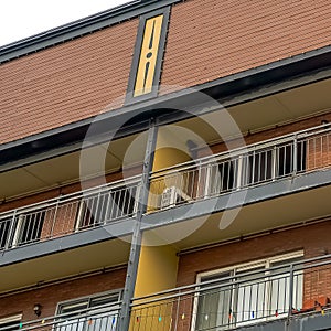 Square Residential building with flat roof balconies and red brick exterior wall