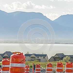 Square Road under construction with blurry view of homes lake and mountain against sky