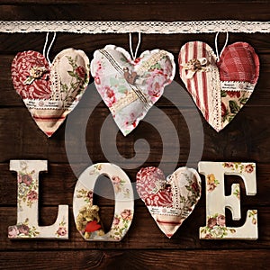 Square shape wooden background with handmade hearts and diy LOVE letters
